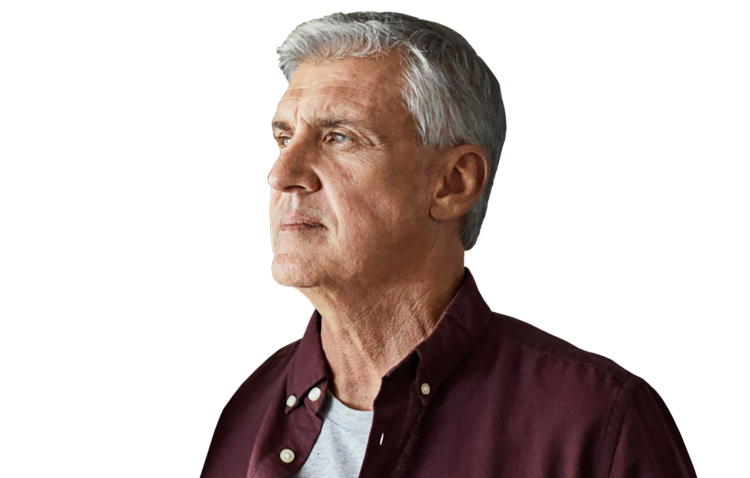 A man wearing a collared shirt over his undershirt looking into the distance